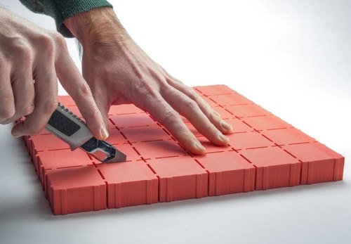 Person som skär i sylomer® PAD Platta